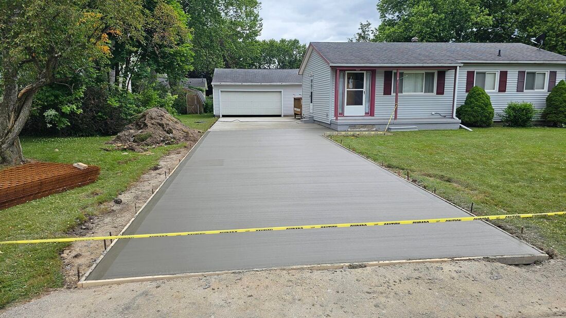 An image of a concrete driveway in front of a house